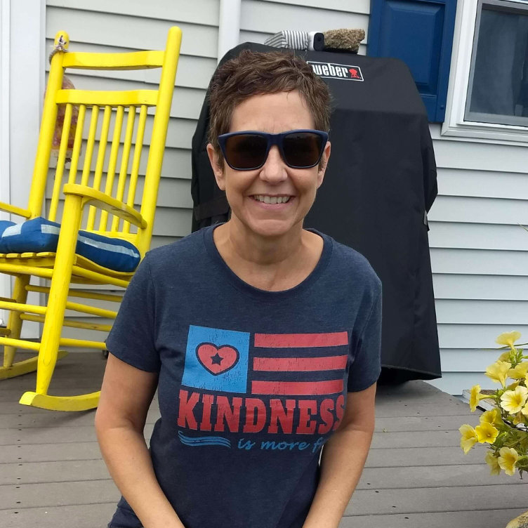 Joanne C. - happy customer wearing our Kindness is More Fun Tee